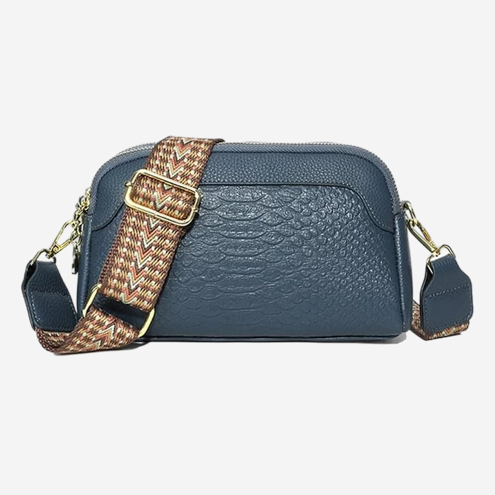 A navy blue crossbody bag with a patterned strap and a zipper closure.