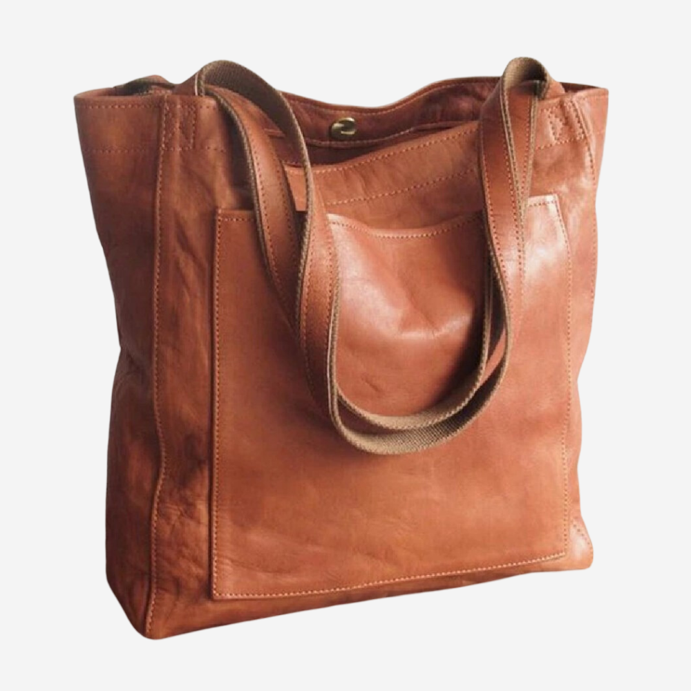 A brown leather tote bag with a strap and a flap pocket.