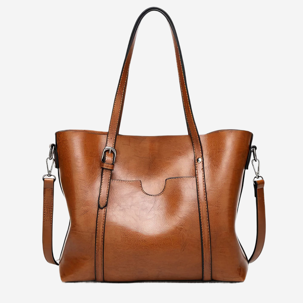 A brown leather tote bag with a curved handle and two shoulder straps.