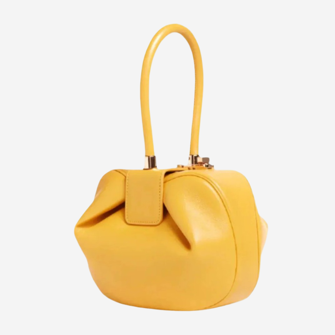 A yellow leather handbag with a curved handle and a small zipper closure.