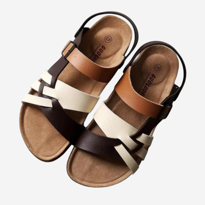 A pair of sandals with a brown leather strap and a white strap.