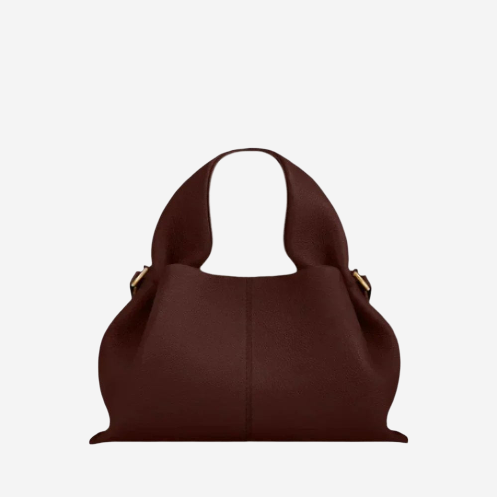 A brown leather handbag with a curved handle and two gold-colored buckles.