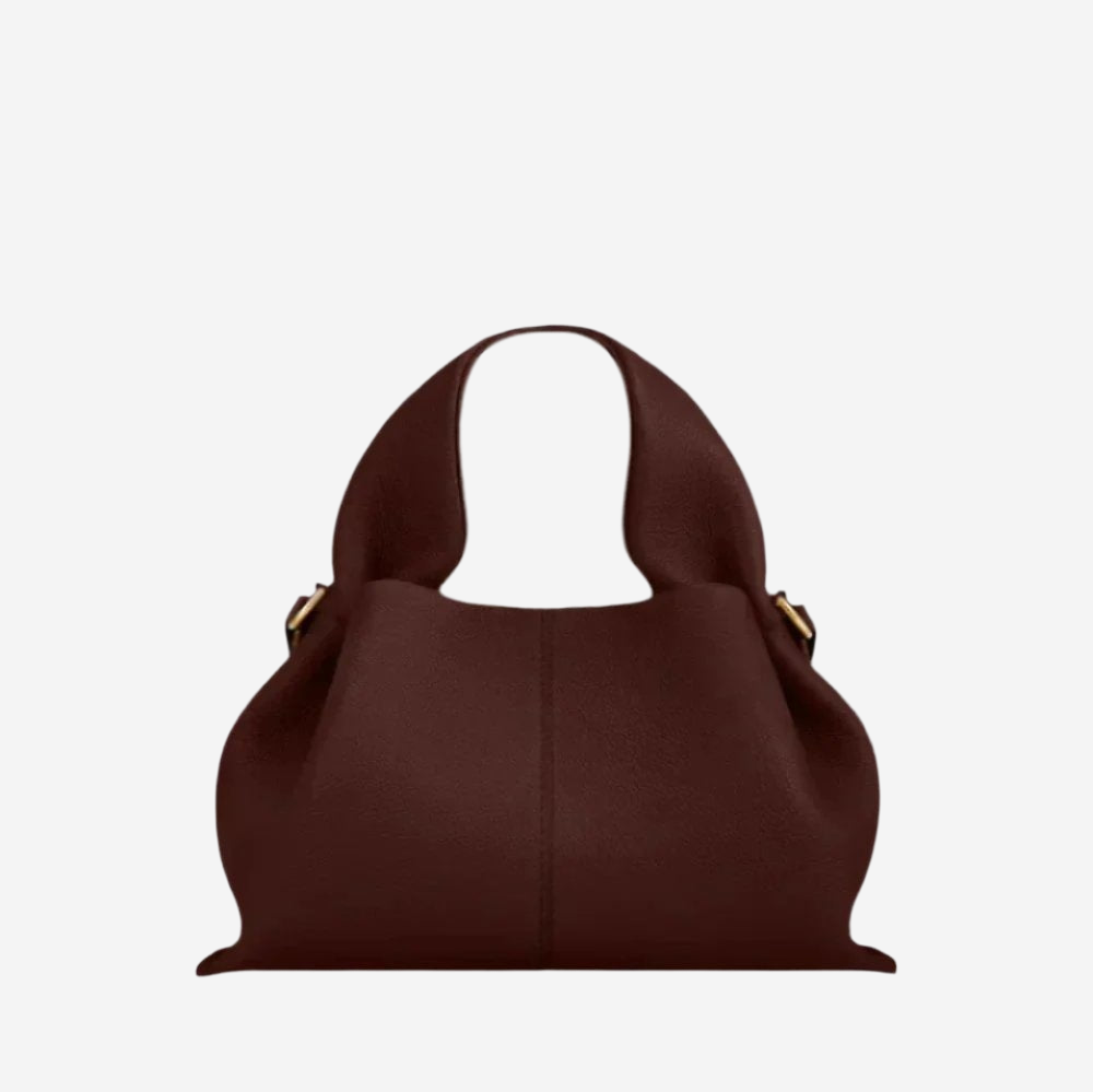 A brown leather handbag with a curved handle and two gold-colored buckles.