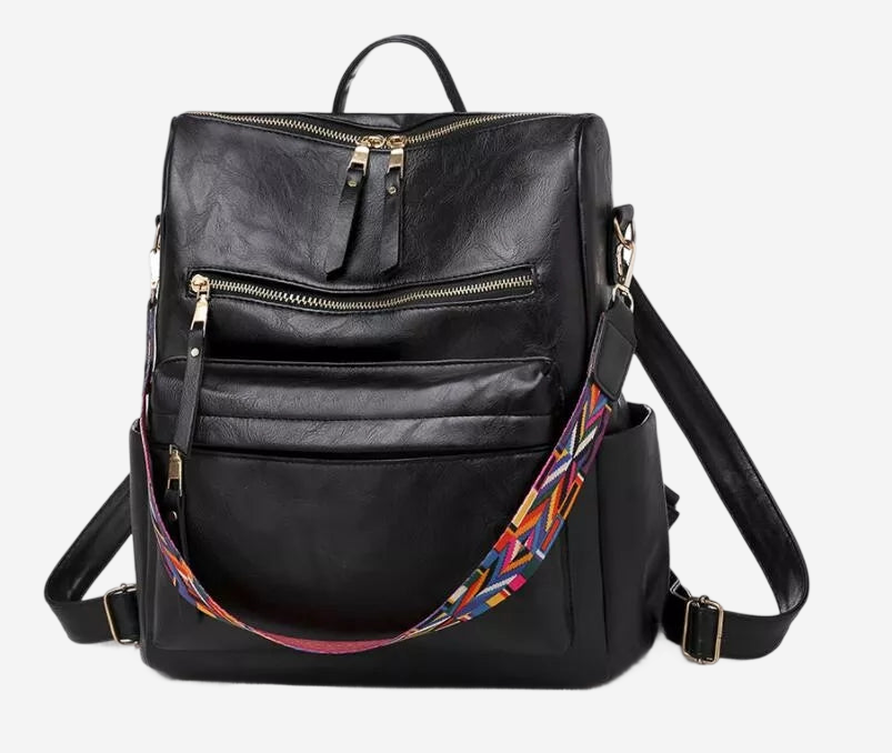 A black leather backpack with multiple zippers and a colorful strap.
