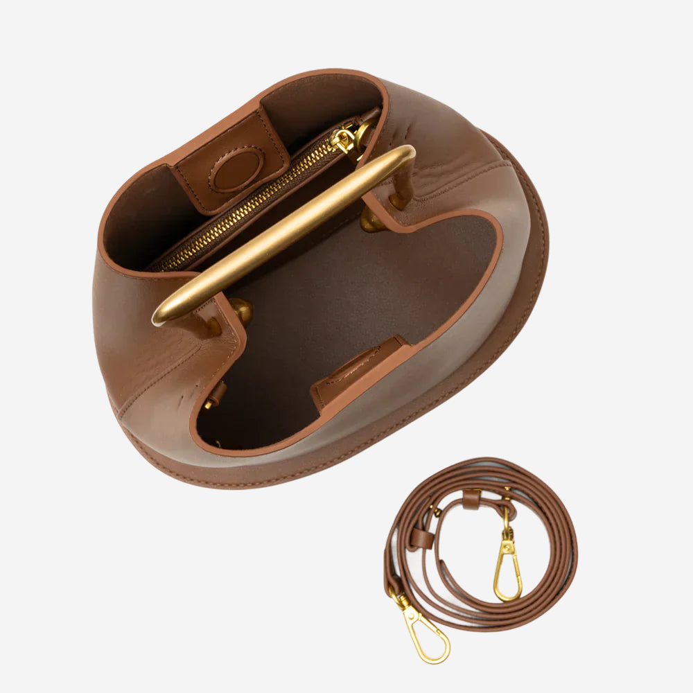 a brown leather handbag with a gold zipper and handle, and a matching gold-colored leather strap.