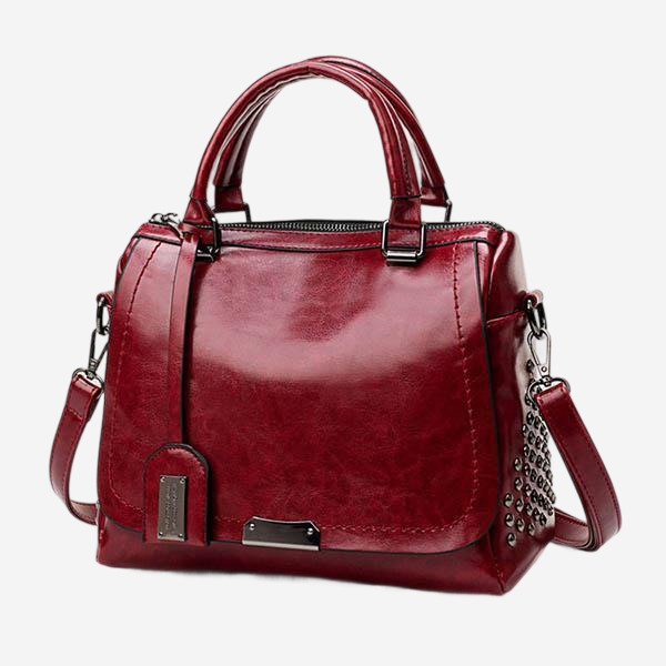 A red leather handbag with a metallic hardware design.