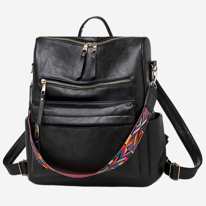 A black leather backpack with multiple zippers and a colorful strap.