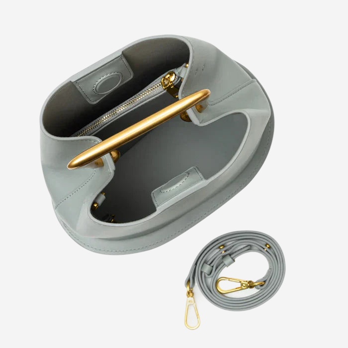 a gray handbag with a gold handle and a matching gold strap.