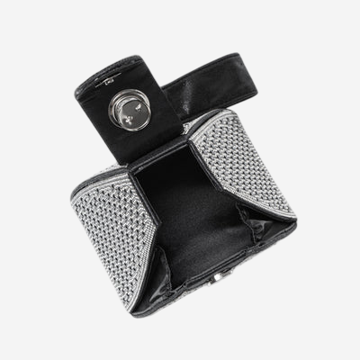 A black and silver handbag with a metallic texture and a circular clasp.