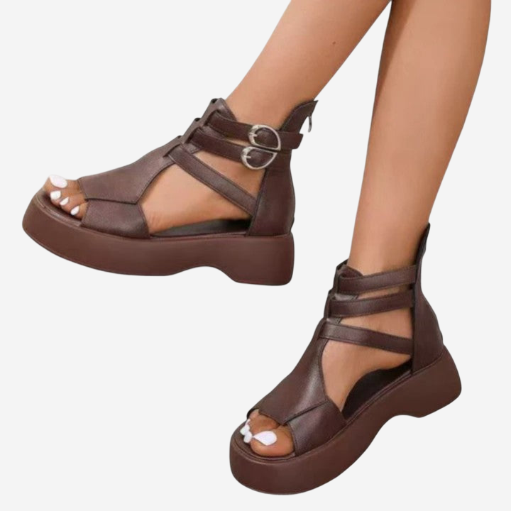 A pair of brown platform sandals with straps and buckles.