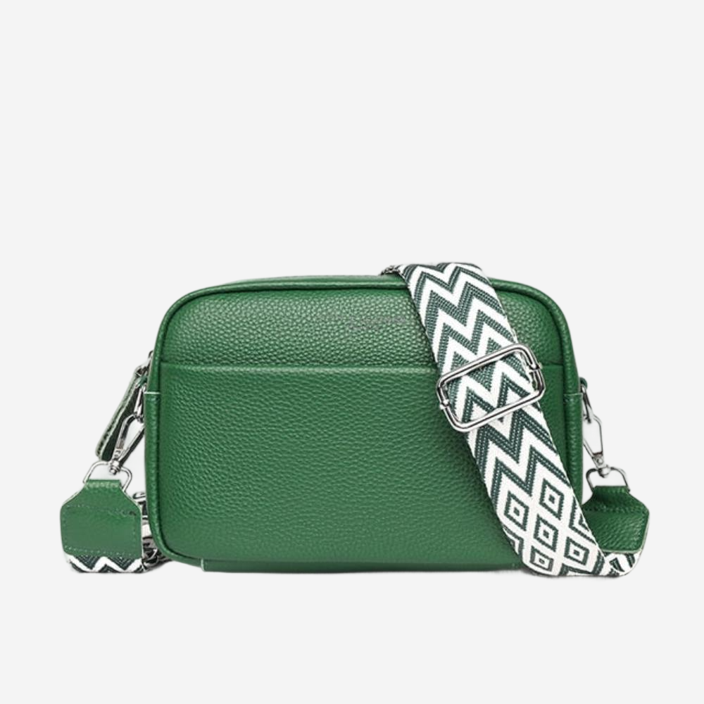 A green leather crossbody bag with a zigzag patterned strap.