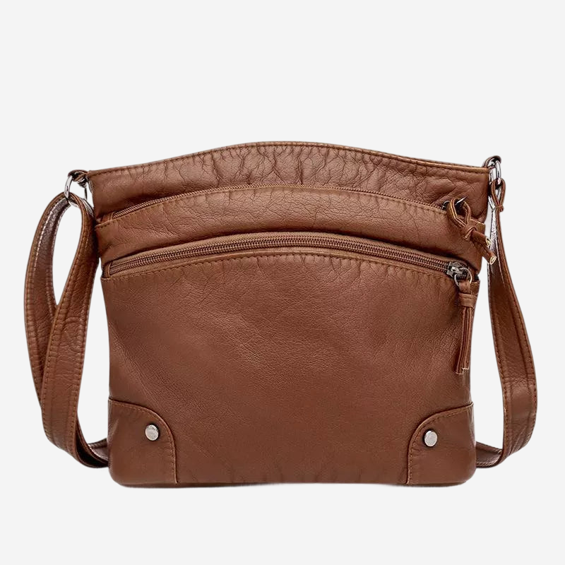 A brown leather crossbody bag with multiple pockets and zippers.
