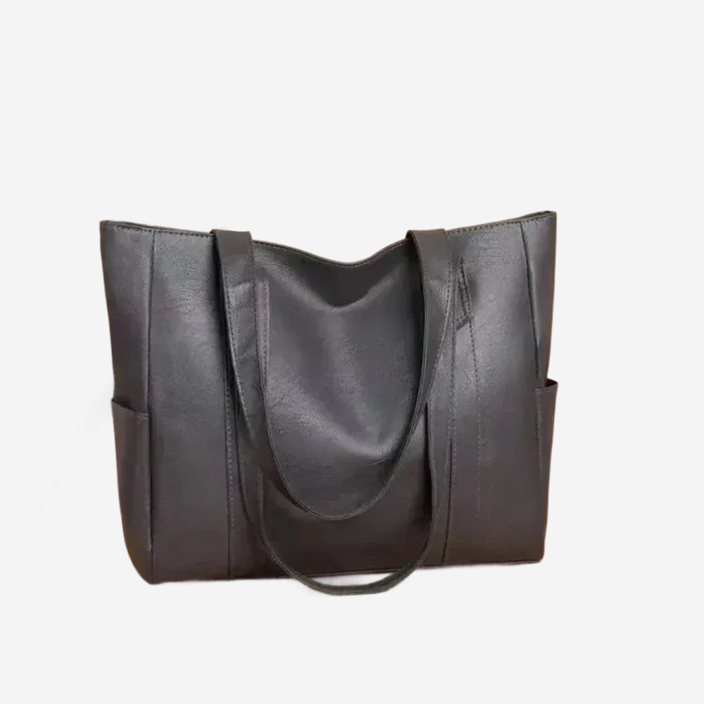 A black leather tote bag with a curved handle and two pockets.