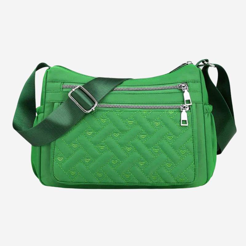 A green crossbody bag with a quilted pattern and a zipper closure.