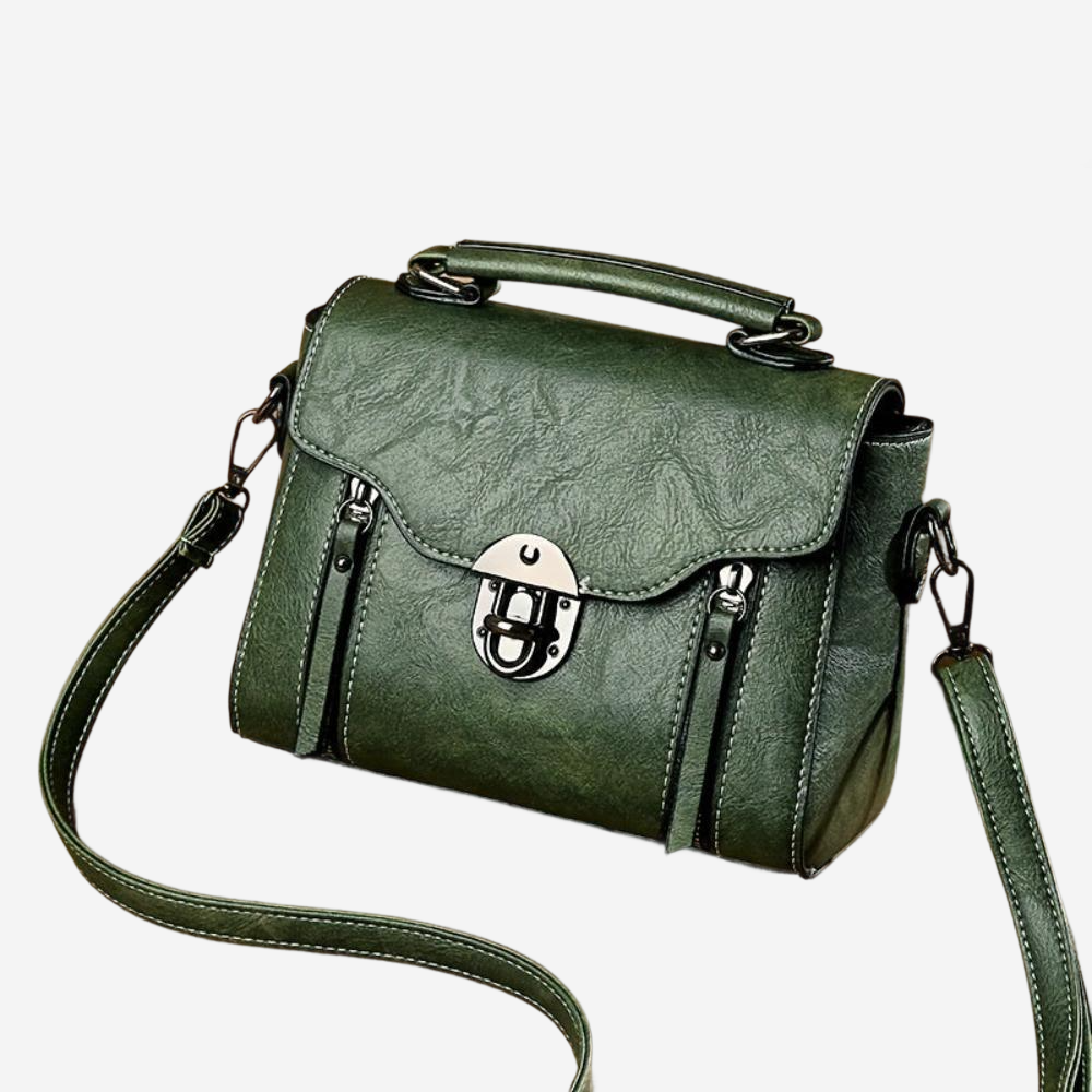 A green leather handbag with a metal clasp and handle, featuring multiple pockets and straps.