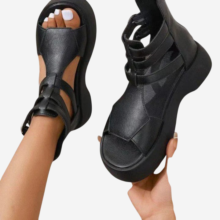 A pair of black platform sandals with straps and a high platform sole.