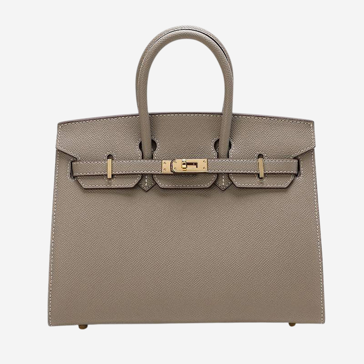 A tan leather handbag with a gold-colored metal clasp and two metal buckle straps.