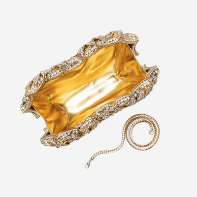 A gold and diamond-encrusted clutch purse is shown, with a chain attached to it.