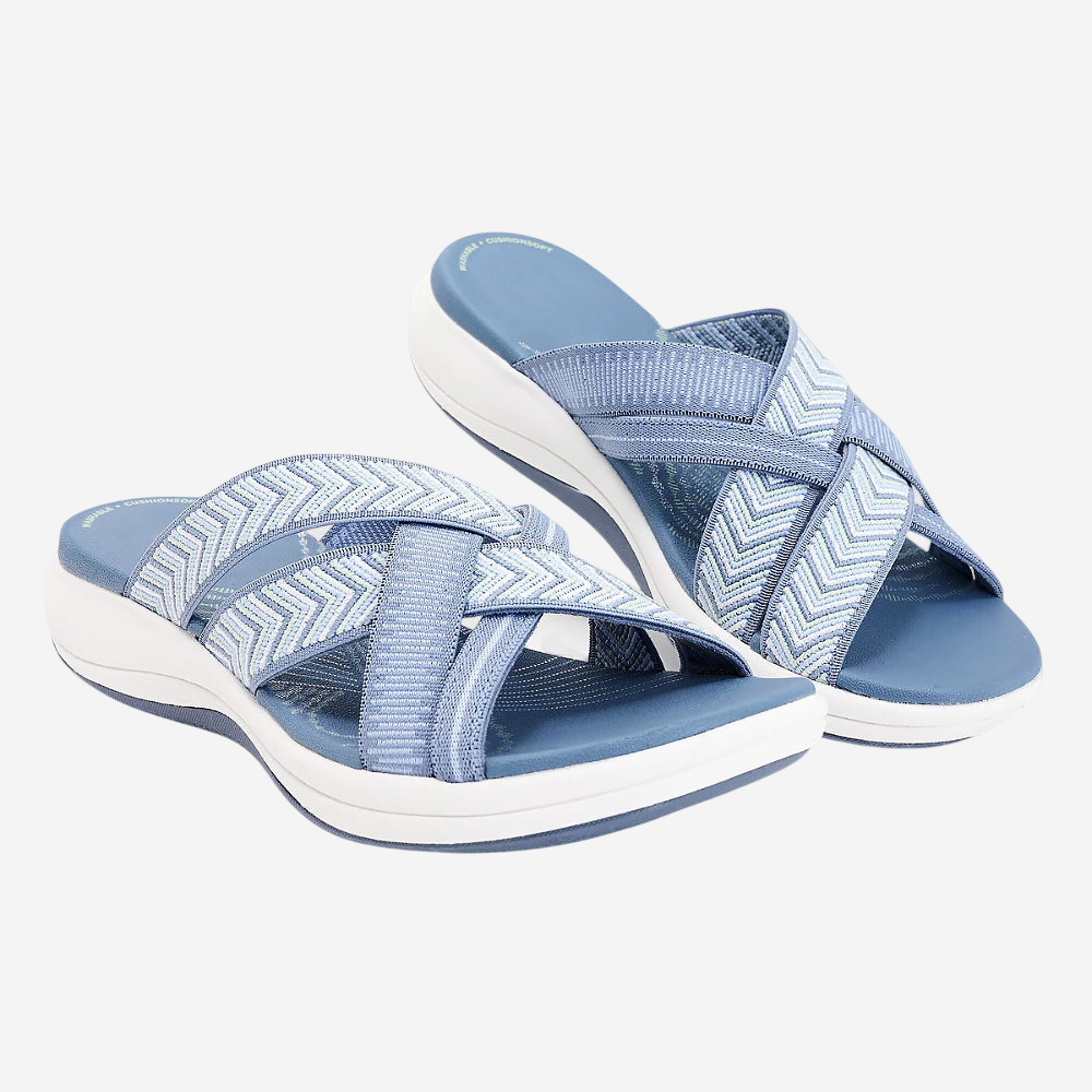 A pair of blue and white patterned sandals with zigzag designs.