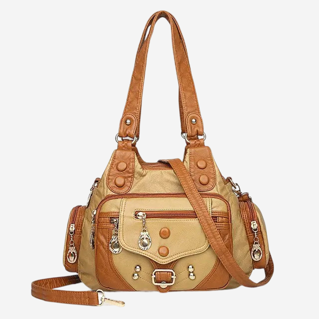 A tan and brown leather handbag with multiple pockets and zippers, featuring a gold-tone hardware and a long strap.
