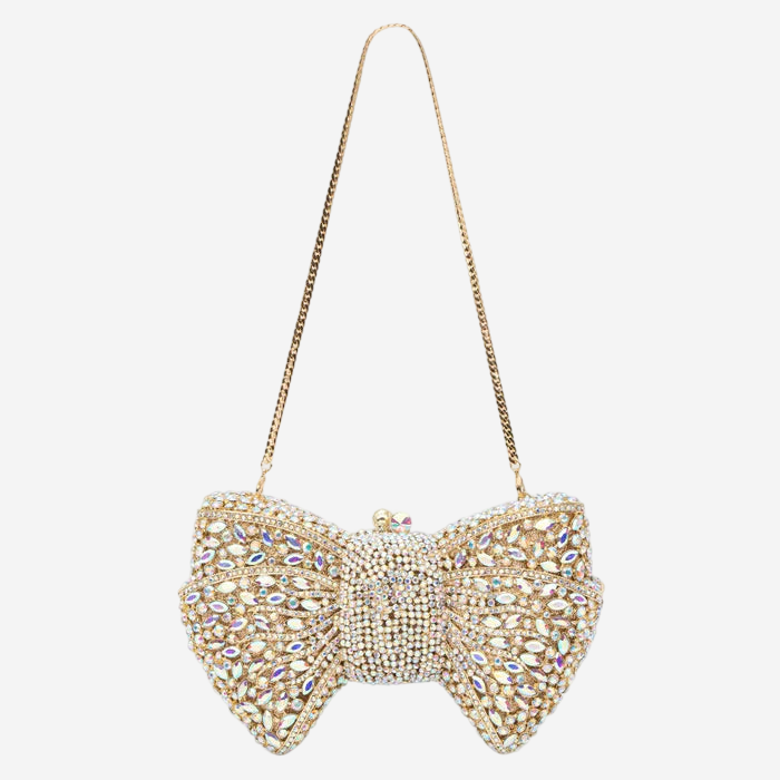 A handbag with a gold chain strap and a large, intricately designed bow made of sparkling rhinestones.