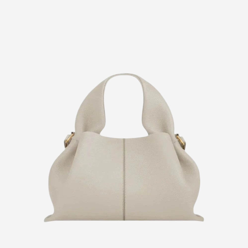A beige leather handbag with a curved handle and two gold-colored clasps.