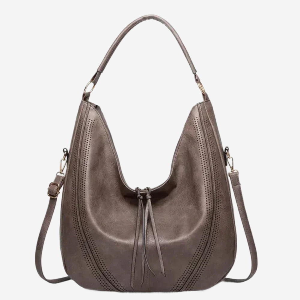 A brown leather handbag with a curved shape, two shoulder straps, and a tassel at the front.
