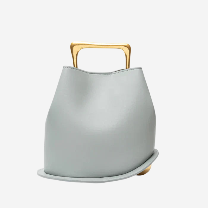 A light gray leather handbag with a gold handle.