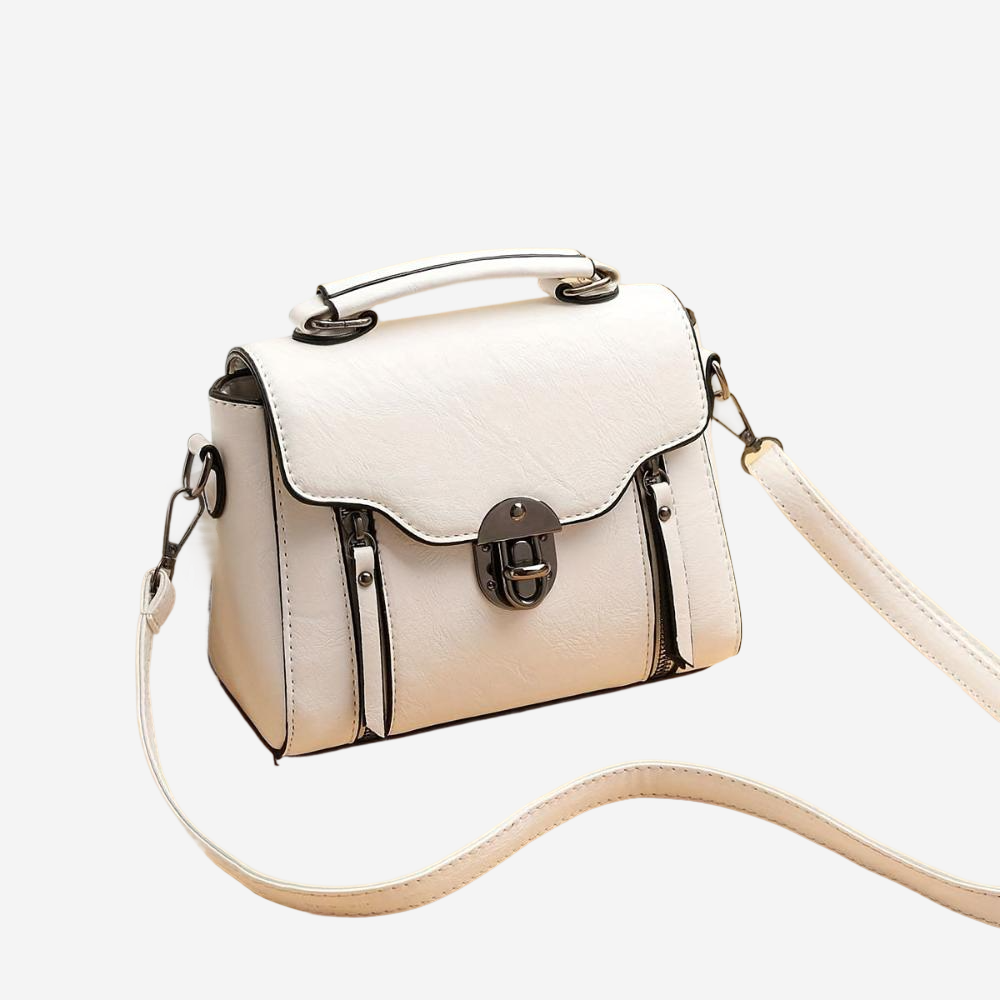 A white leather handbag with a metal clasp and handle, featuring multiple pockets and zippers.