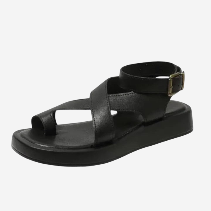 A black leather sandal with a strap across the ankle.