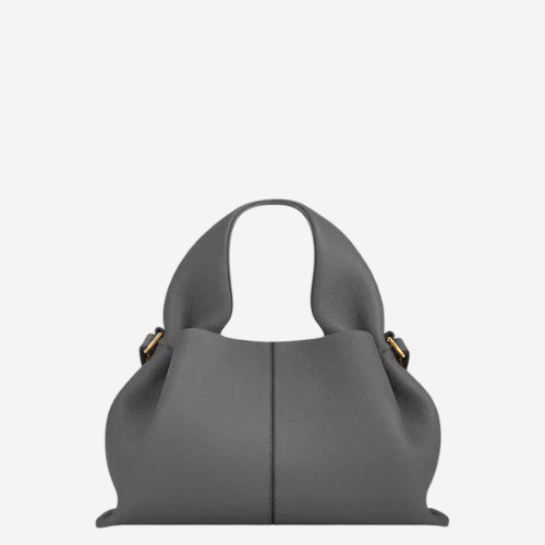 A gray leather handbag with a curved handle and two gold-colored buckles.