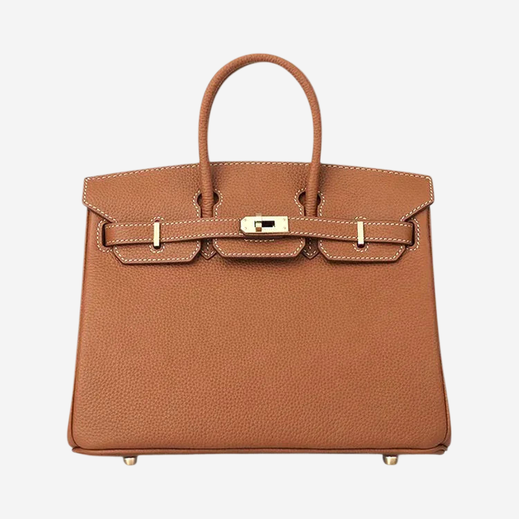 A brown leather handbag with a gold hardware and two straps.