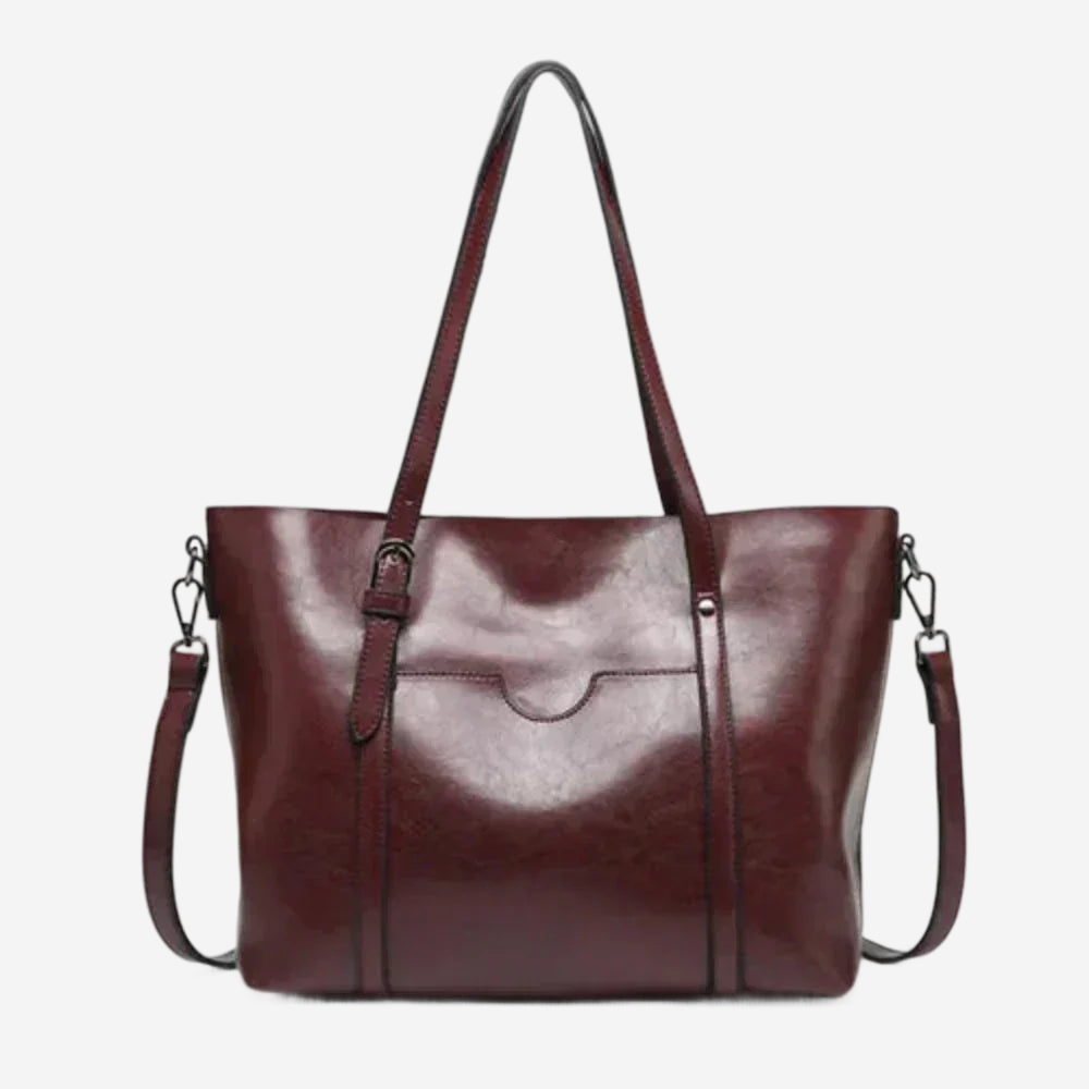 A burgundy leather tote bag with a long strap and two metal clasps on the front.