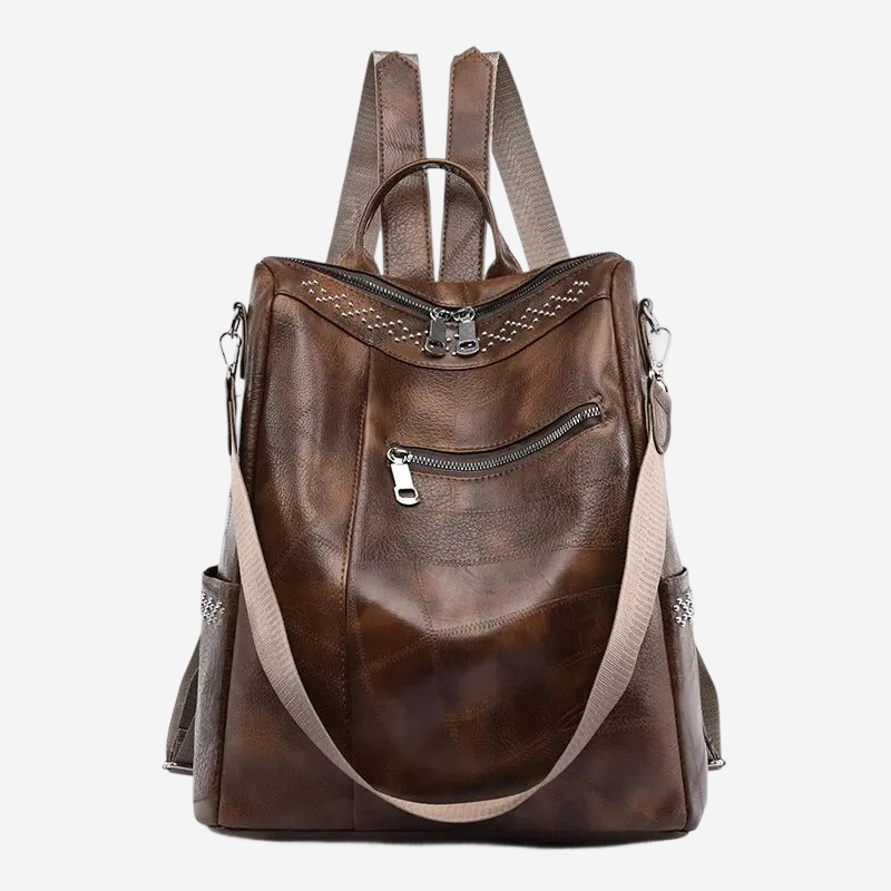 A brown leather backpack with multiple zippers and pockets, featuring a beige strap.