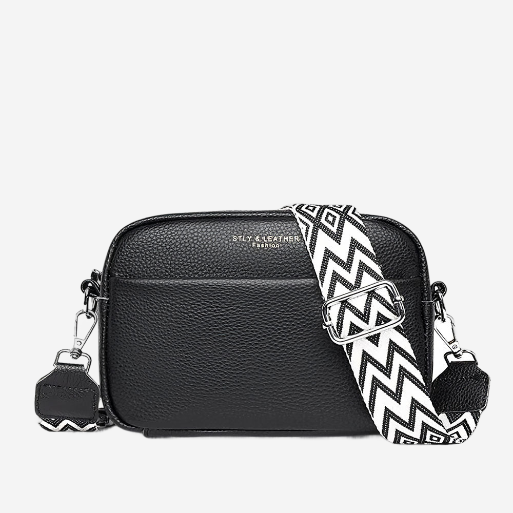 A black leather crossbody bag with a zigzag patterned strap.