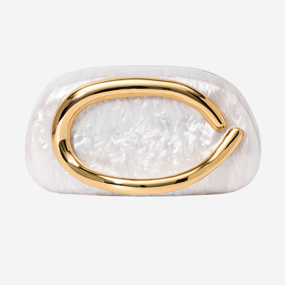 A white, oval-shaped object with a gold-colored curved element on it.