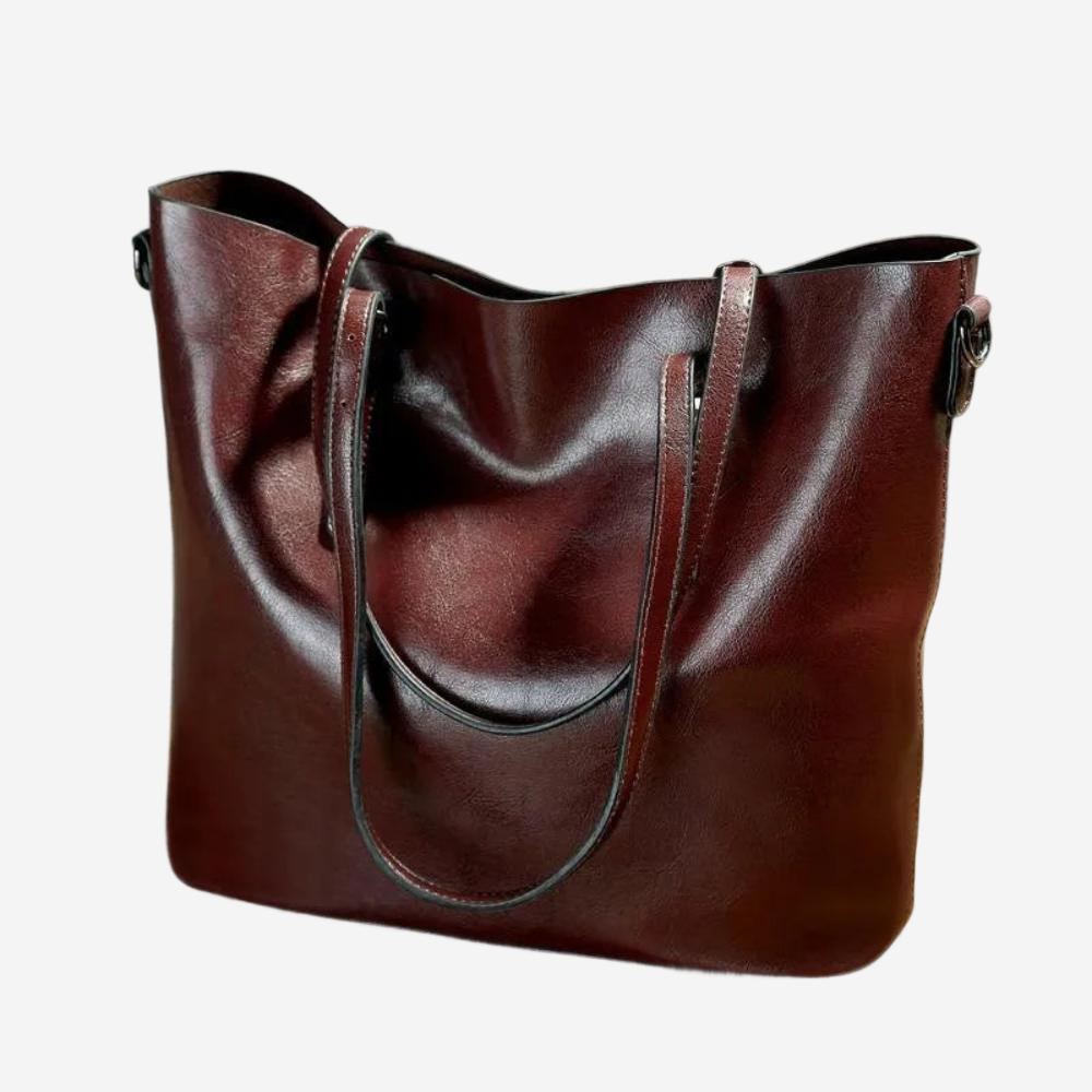 A large, burgundy leather tote bag with a curved handle and two straps.