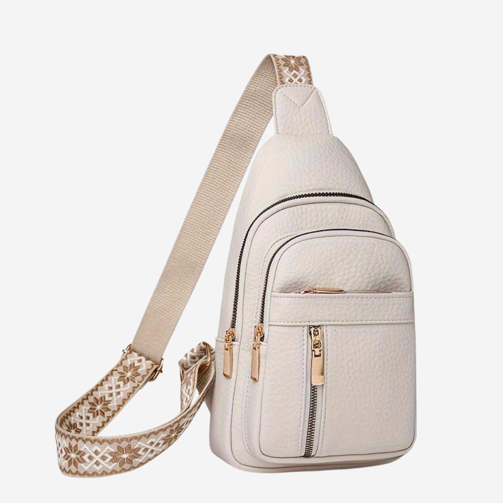 A white crossbody bag with multiple pockets and zippers, featuring a beige strap with a floral pattern.