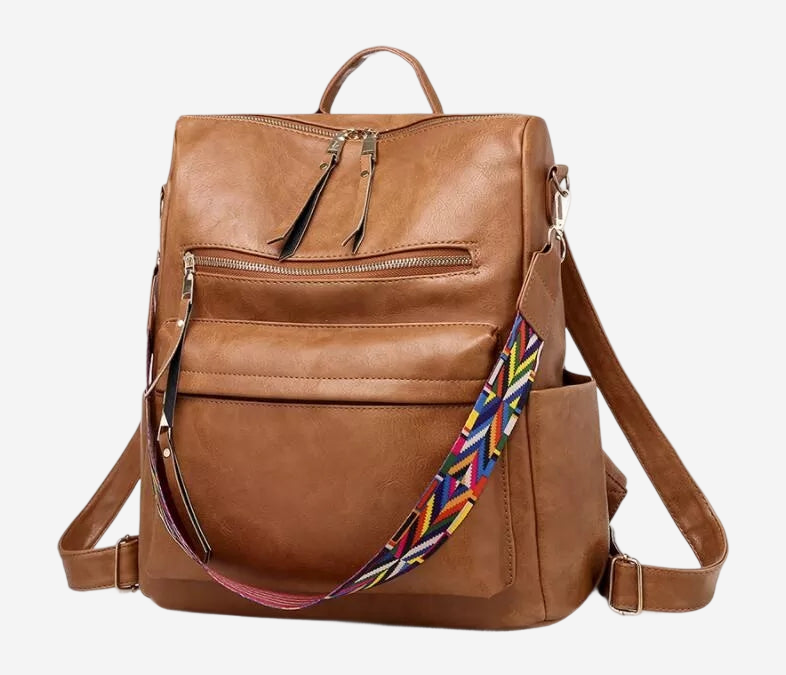 A brown leather backpack with multiple pockets and zippers, featuring a colorful patterned strap.