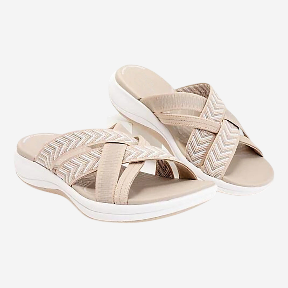 A pair of beige sandals with zigzag patterns on the straps.