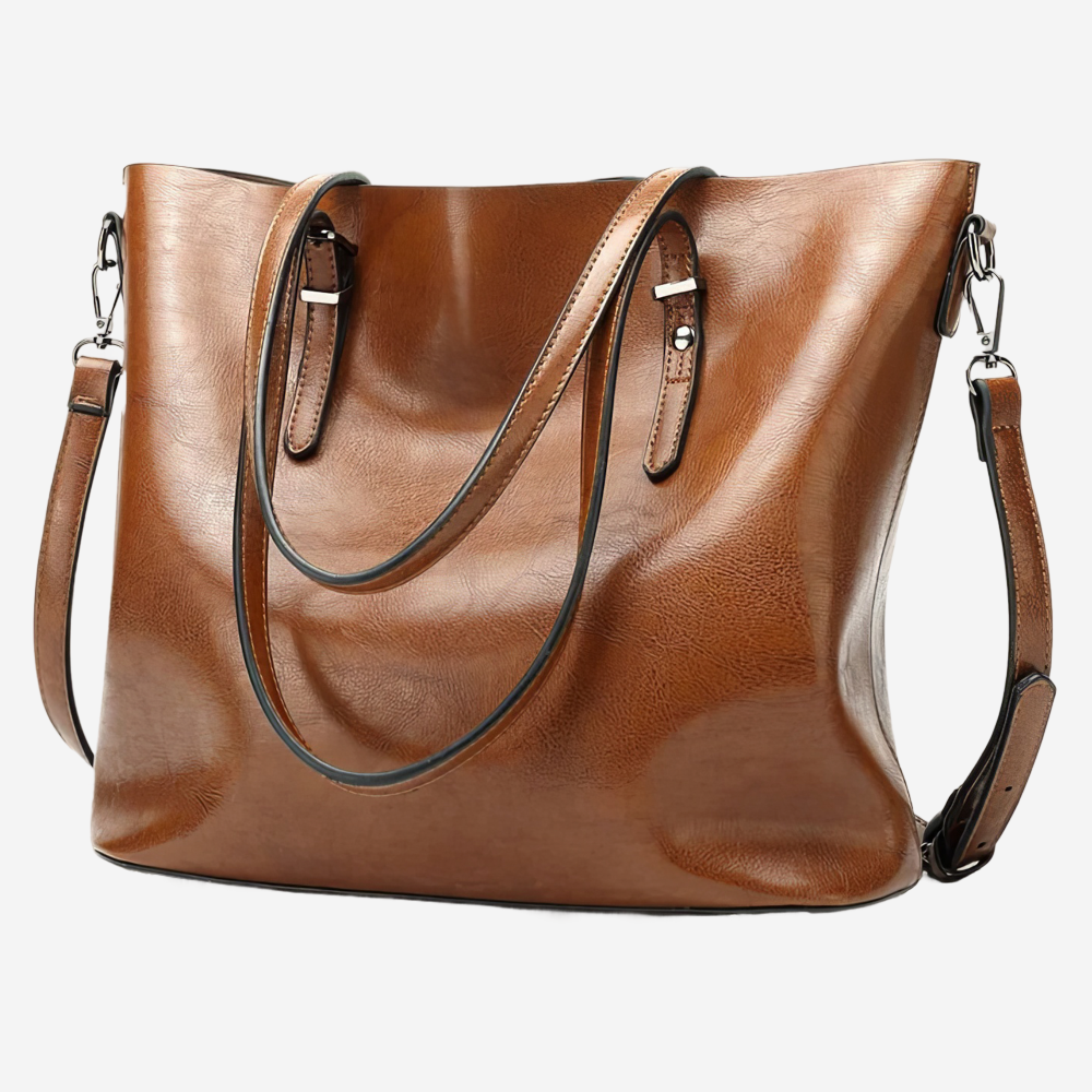 A brown leather tote bag with a black strap and two metal buckles on the handles.