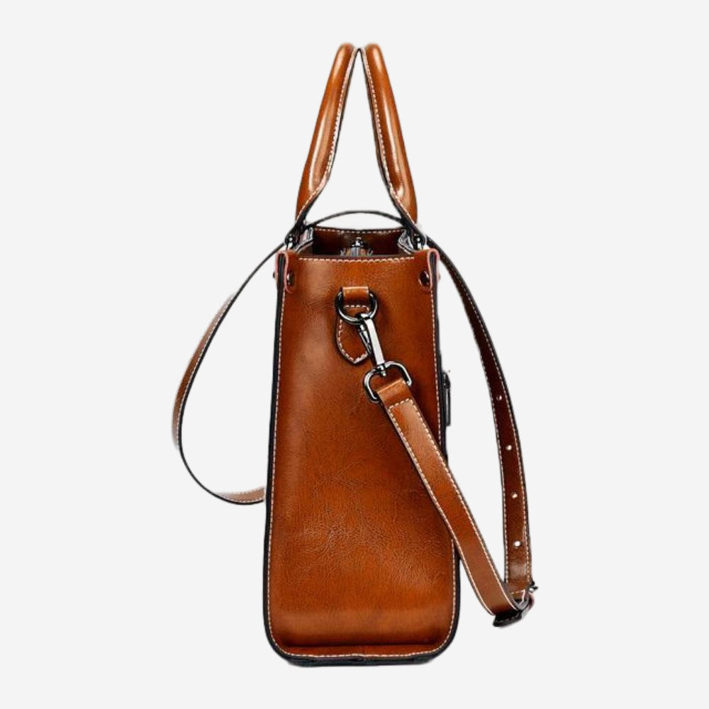 A brown leather handbag with a metal clasp and two leather straps.