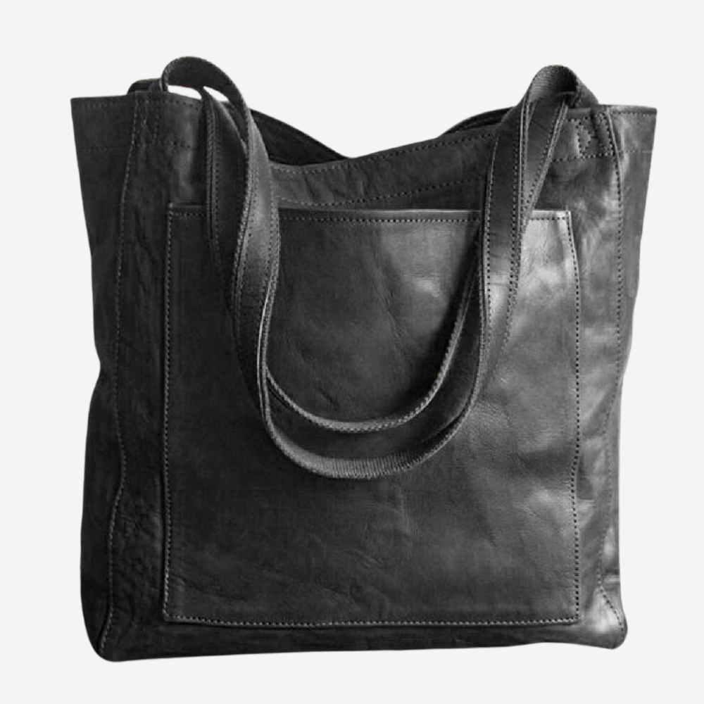A black leather tote bag with a curved handle and a flap closure.
