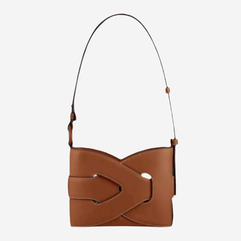 A brown leather handbag with a curved strap and a distinctive cutout in the front.