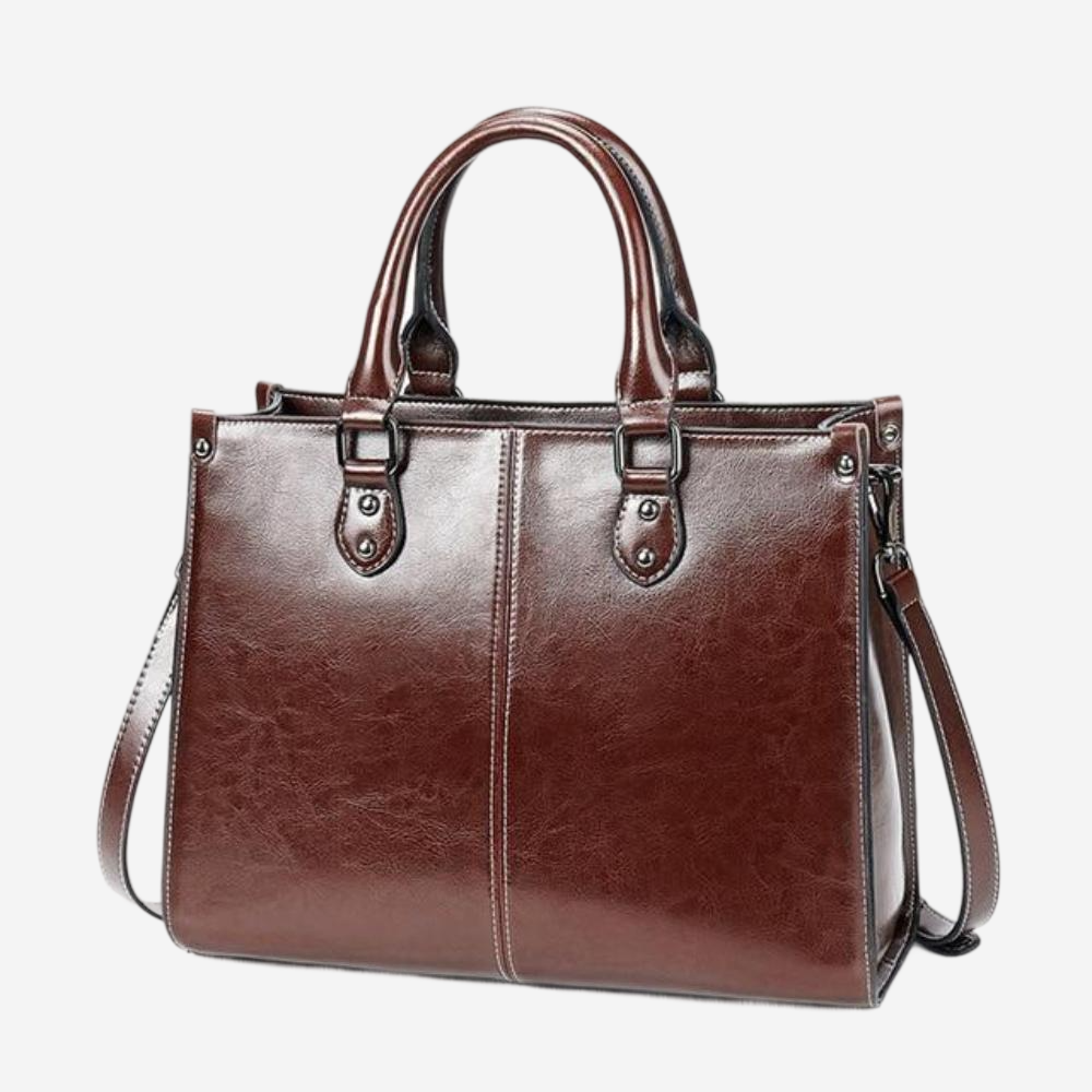 A brown leather handbag with two handles and a shoulder strap.