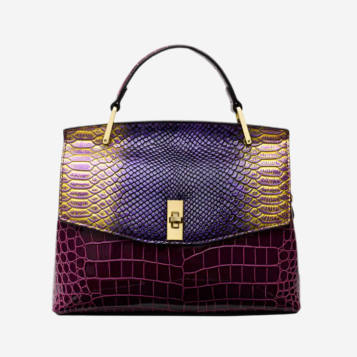 A stylish handbag with a combination of purple and gold colors, featuring a crocodile skin texture and a gold-colored lock closure.