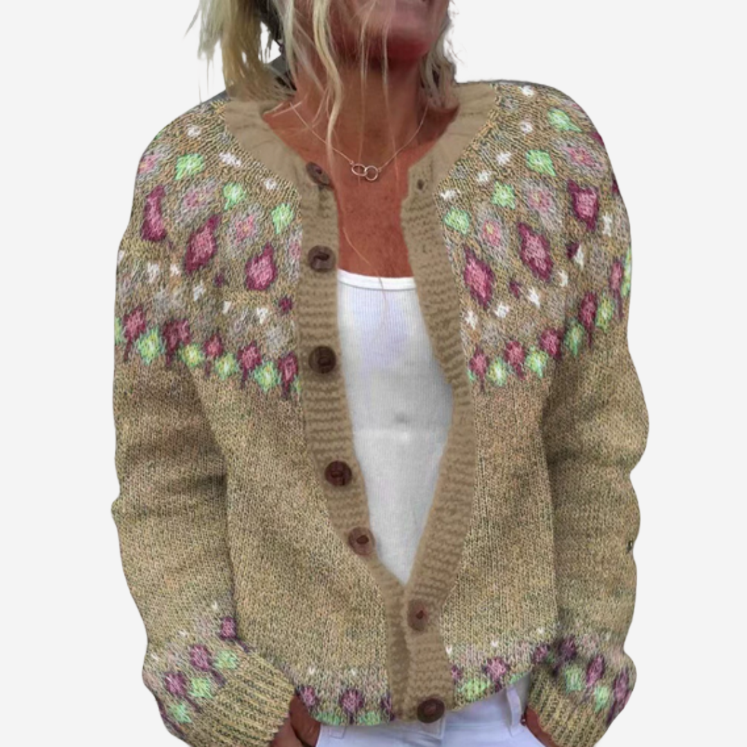 A woman wearing a beige knitted cardigan with colorful floral patterns.