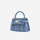 A small, blue denim handbag with a metal clasp and handle.