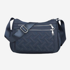 A navy blue crossbody bag with a quilted pattern and multiple zippers.