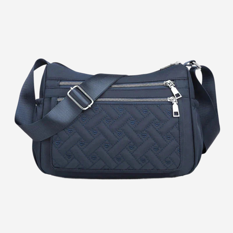 A navy blue crossbody bag with a quilted pattern and multiple zippers.